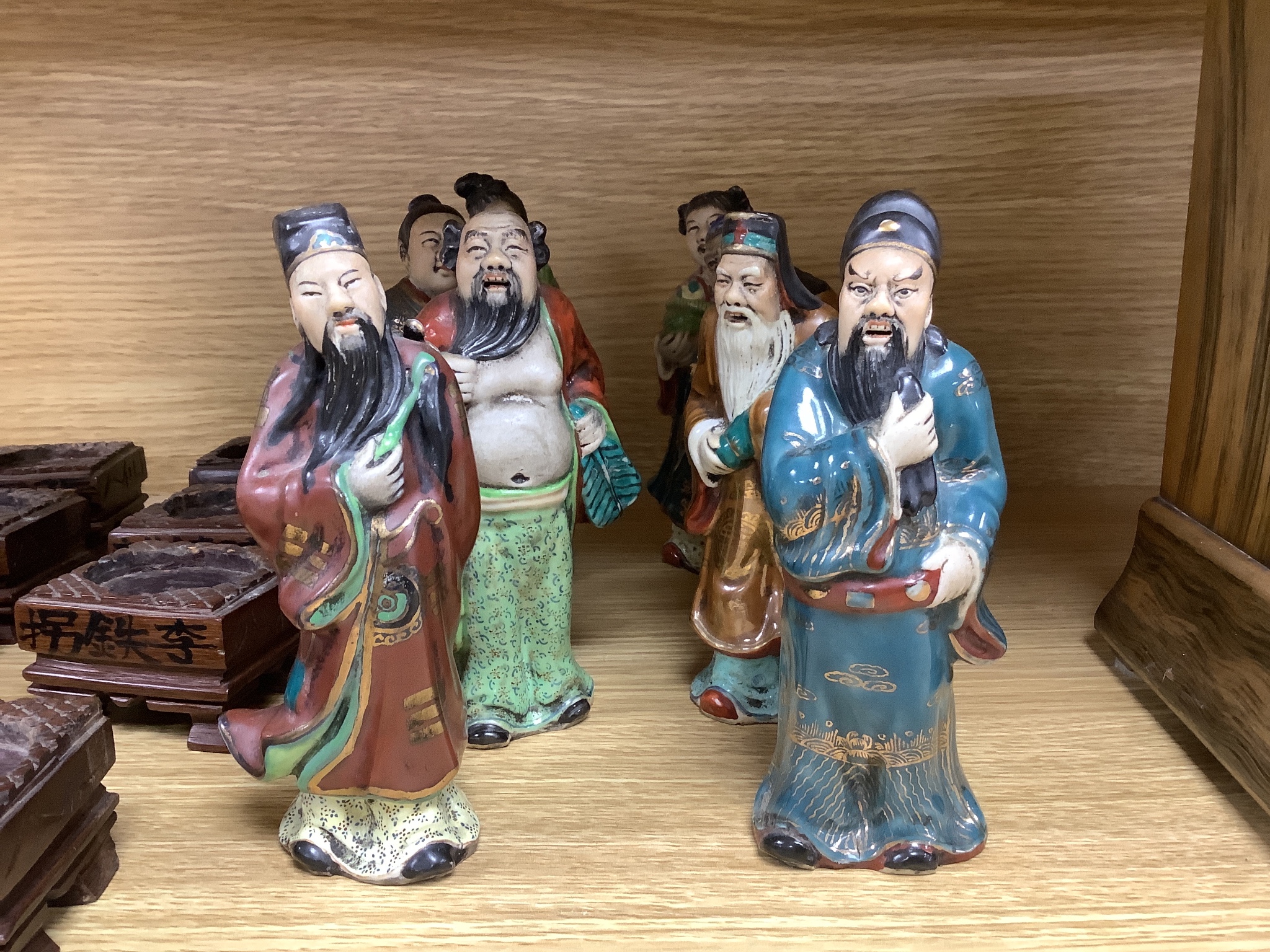 A set of eight 20th century Chinese porcelain figures of immortals, 15cm, each on carved wood stand